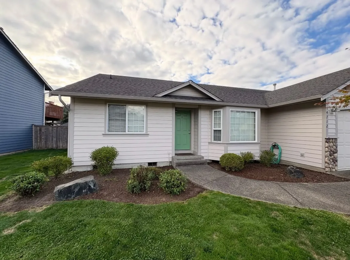 Front yard with freshly maintained flower beds and lawn